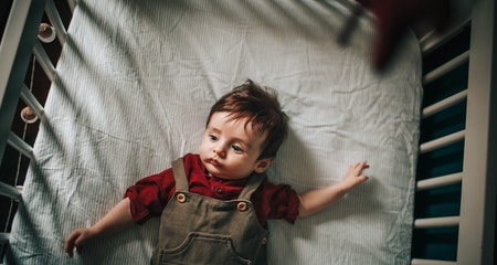 Cute baby resting in crib in daytime 