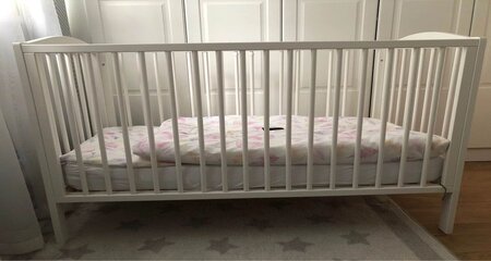 White clolor baby crib in the room