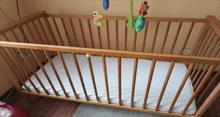 Wooden baby crib next to the wall