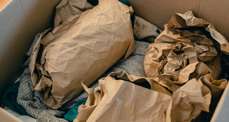 Box with object wrapped in brown paper