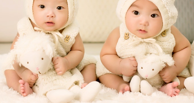 Twins babies sitting on the bed