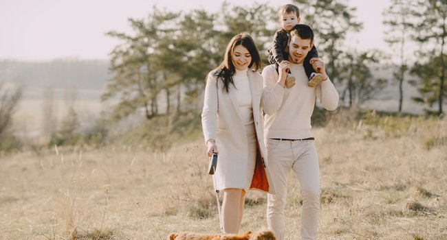 Photo of family walking with their brown dog