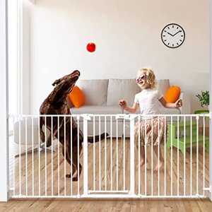 A toddler playing with a dog next to the baby gate