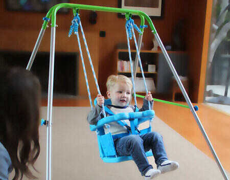 a Kid sitting on a traditional old style baby swing