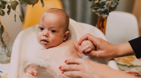 Baby taking shower in the bathtub