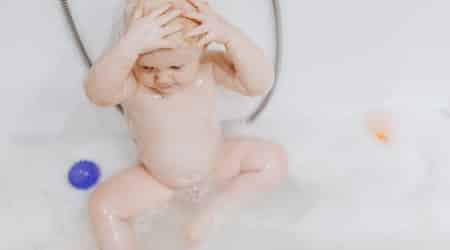 Baby taking shower alone in the bathroom