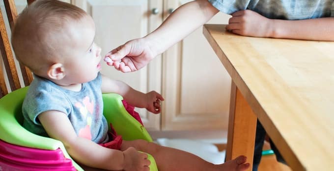 Baby eating food on a chair