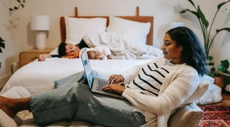 A Black woman is working on her laptop