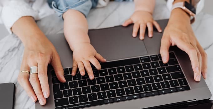 An adult and baby hand on the laptop keyboard